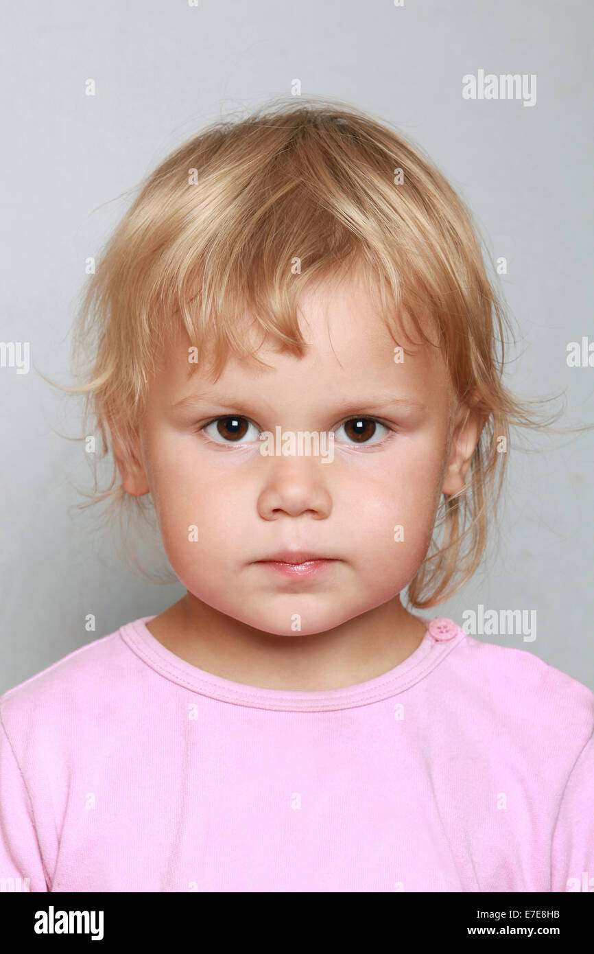 Kaukasische Baby Mädchen Nahaufnahme Portrait. Kopfschuss auf grau Stockfoto