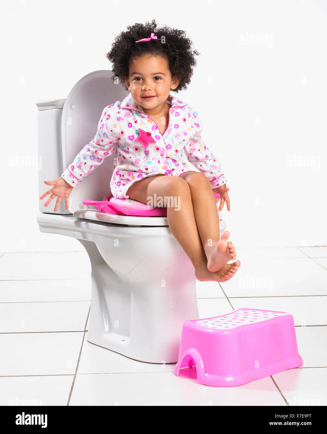 Babymädchen mit WC-Sitz Stockfoto
