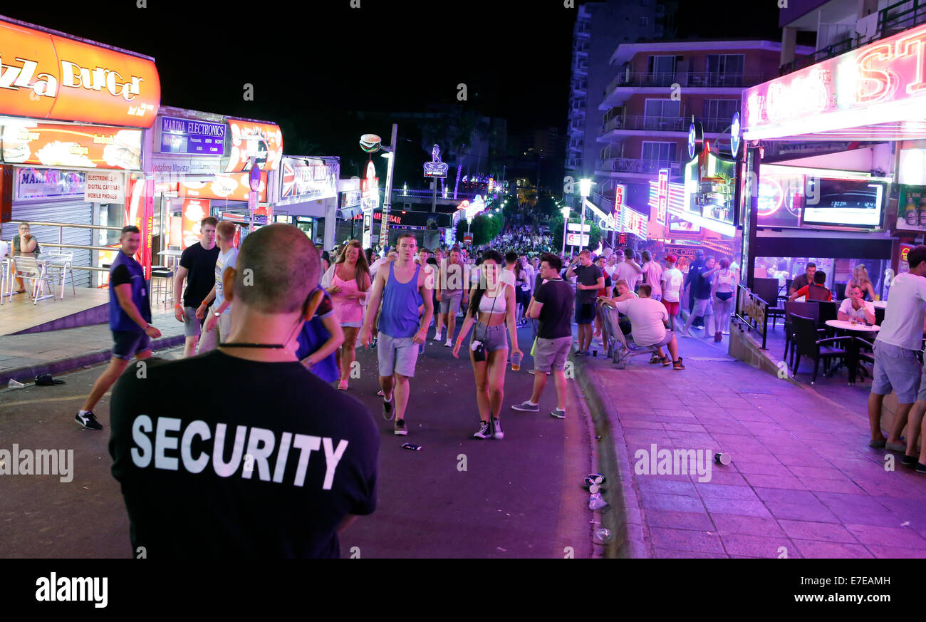 Ein Wachmann beobachten junge britische Touristen in Punta Ballena in Magaluf auf der spanischen Insel Mallorca genießen Stockfoto