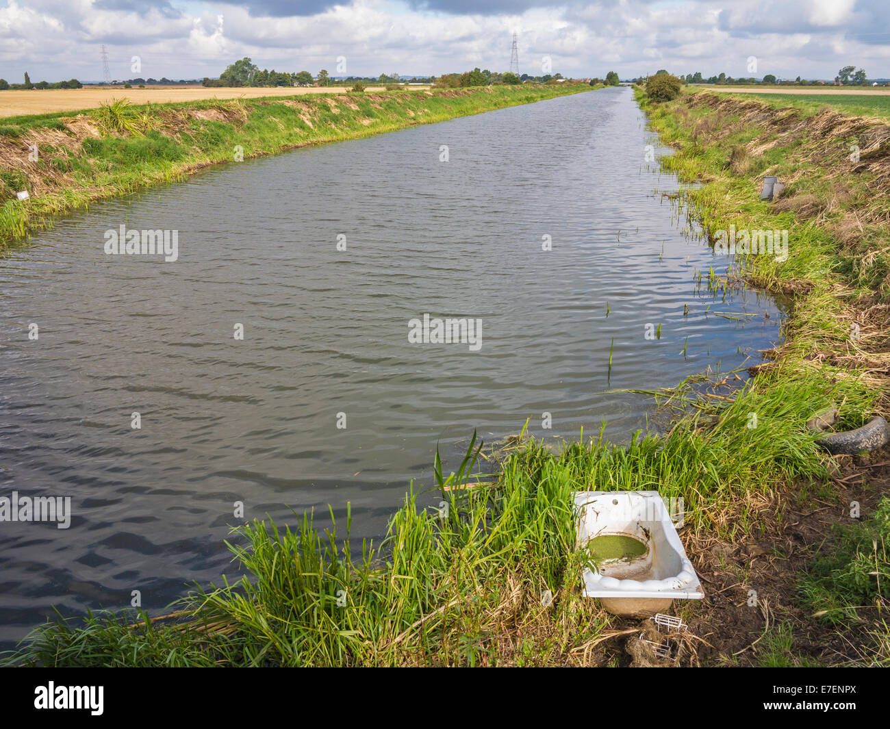 Eine Entwässerung Deich in Lincolnshire Venn mit einer alten Badewanne hinein geworfen Stockfoto