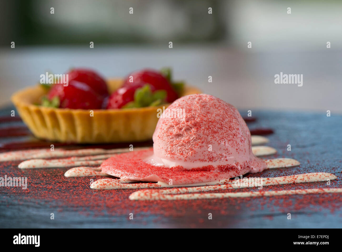 Gourmet-Melting Erdbeereis Dessert auf einer Schiefertafel Platte mit einer Schüssel Erdbeeren Stockfoto