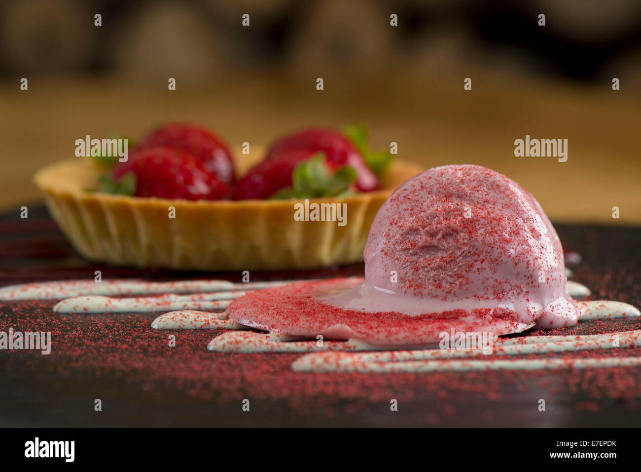 Gourmet-Melting Erdbeereis Dessert auf einer Schiefertafel Platte mit einer Schüssel Erdbeeren Stockfoto