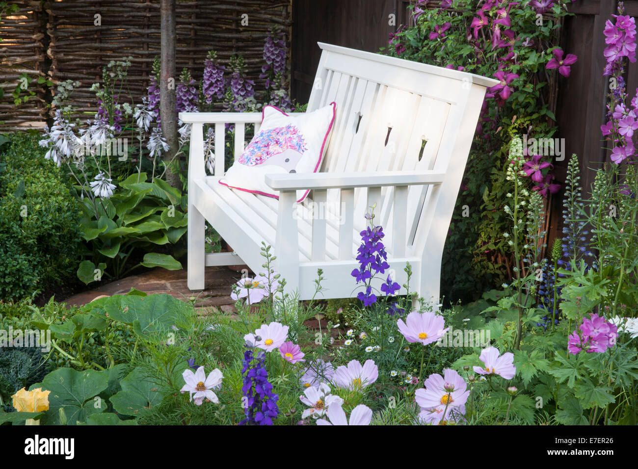 Garten - Igel Garten - Blick auf Garten Sitzbank mit Kosmos im Vordergrund - Designer - Tracy Foster Stockfoto