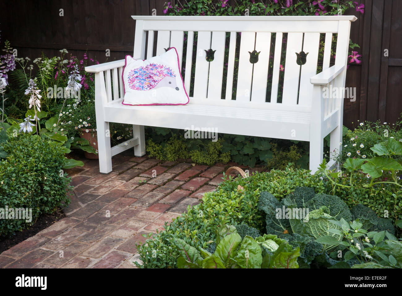Garten - Igel - Blick auf Gartenbank Backstein Pflaster und Box-Hecke mit Savoy Cabbage Mangold und squash Stockfoto