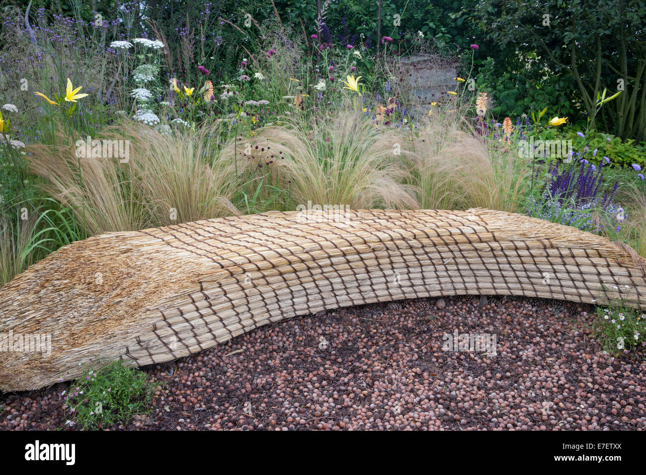 Blick auf den Garten - Jordans Wildlife Garden - der Garten Sitzbank aus Stroh Stroh mit Mulch von Haselnüssen hergestellt- Stockfoto