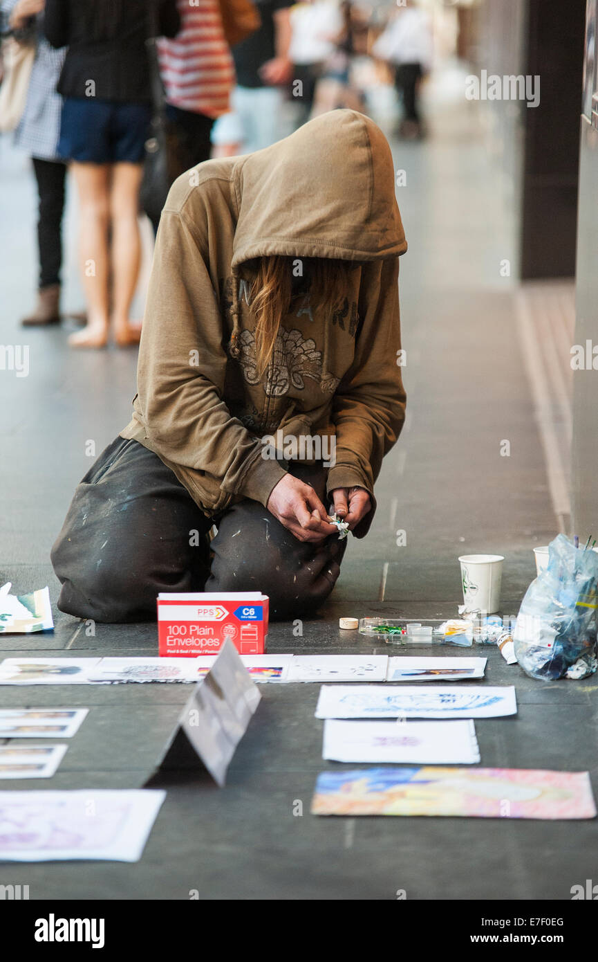 Ein Obdachloser verkauft Kunstwerke in Melbournes Burke Street Mall Stockfoto