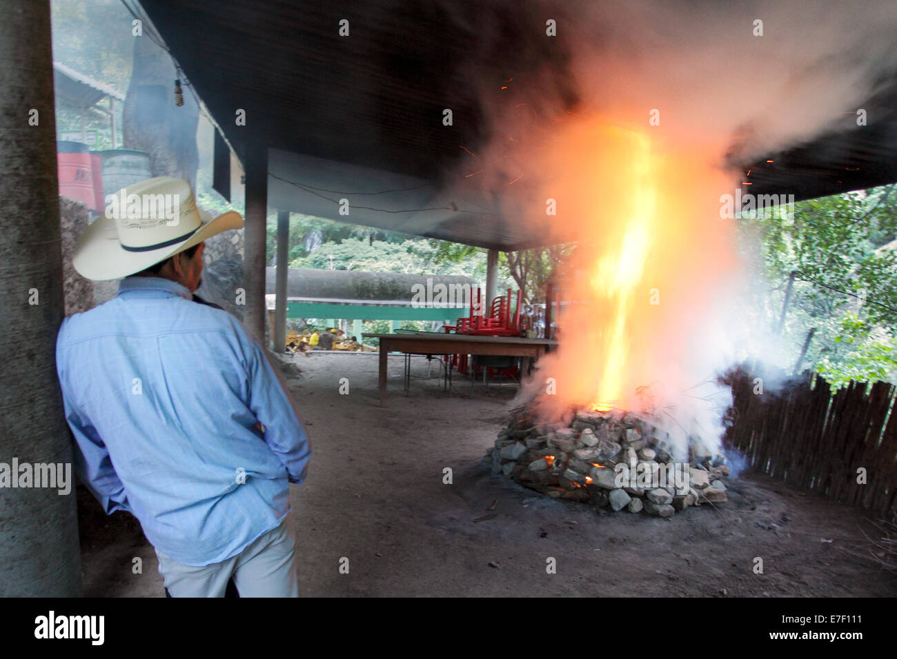 Ein Mann wacht über der Feuerstelle bei der Vorbereitung von Barbacoa, ein würziger Ziegenfleisch, in Tolantongo, Hidalgo, Mexiko. Stockfoto
