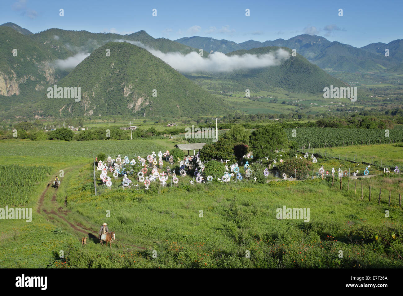 Bauern auf Pferden in der Nähe von einem ländlichen Friedhof in der Nähe von Tuxpan, Michoacan, Mexiko. Stockfoto