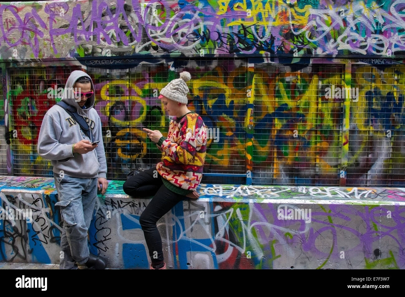 Trendige Mann und Frau Phubbing einander mit Telefon in Graffiti Streetart Verbündeten Hoiser Lane Melbourne Australien Stockfoto
