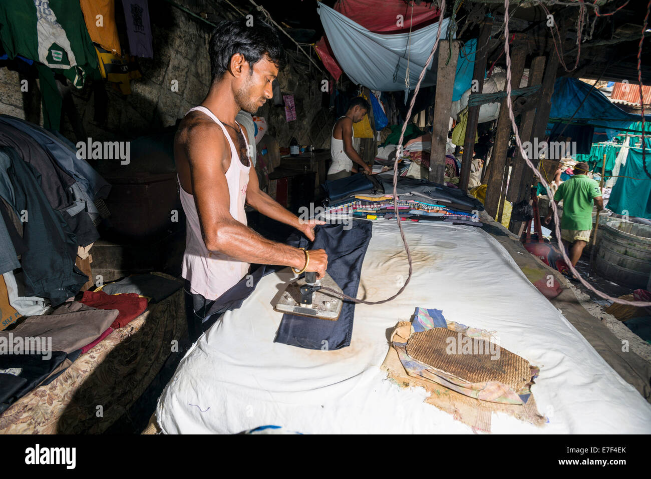 Ein Arbeiter ist Bügeln Wäsche bei Mahalaxmi Dhobi Ghat, Wäsche Bezirk von Mumbai, Maharashtra, Indien Stockfoto