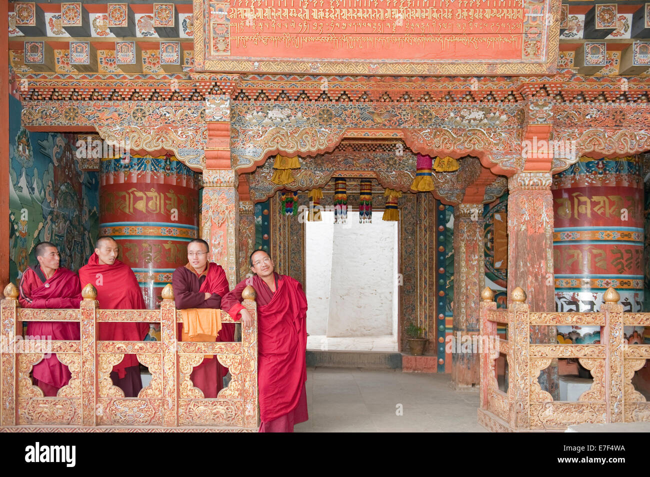 Vier Mönche in roten Gewändern, reich verzierten hölzernen Wand, buddhistische Tango Goemba Kloster in der Nähe von Thimphu, Bhutan-Königreich Stockfoto