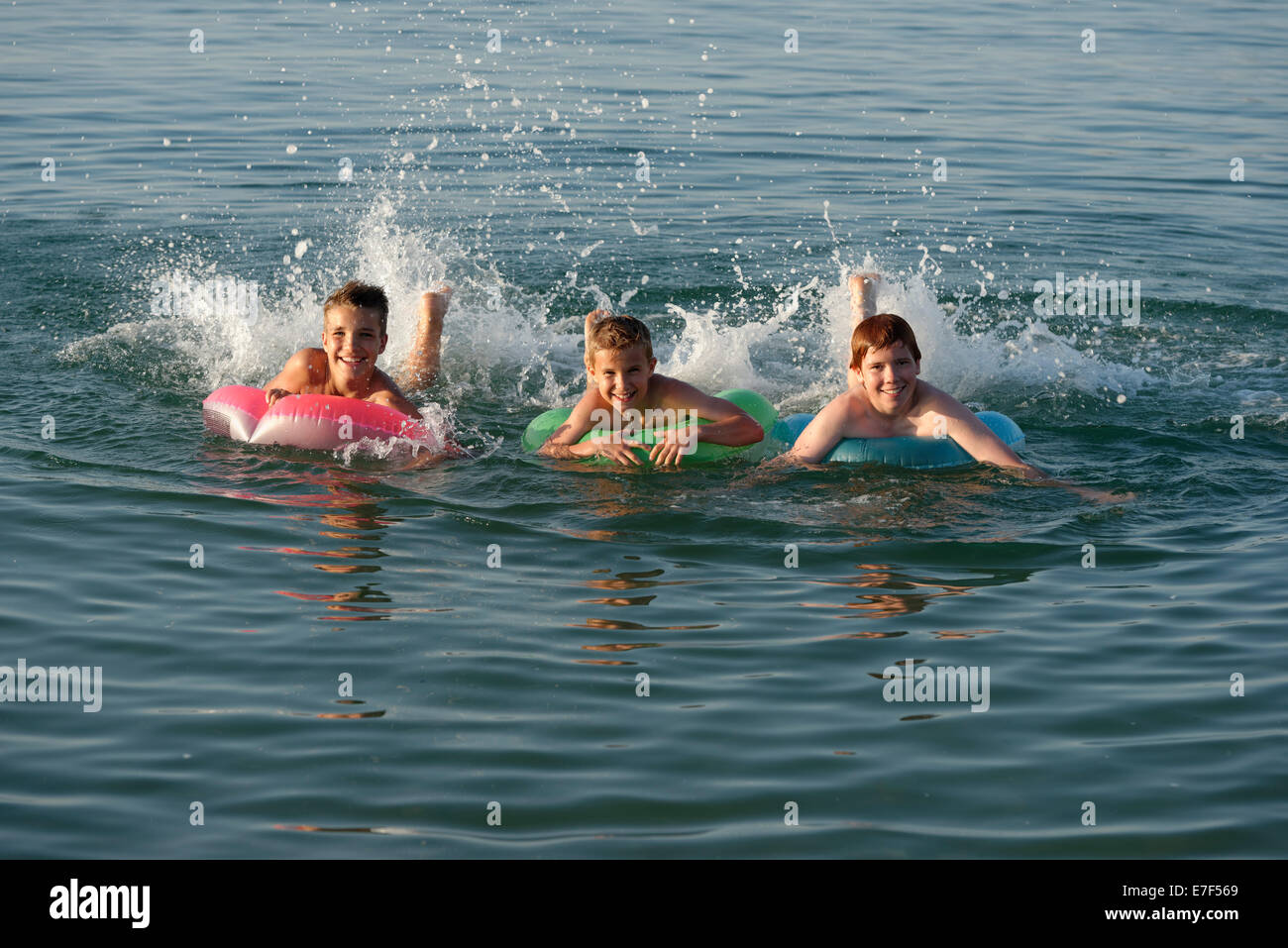 Kinder auf schwimmenden Reifen in das Meer, Mittelmeer in der Nähe von Fano, Marken, Adria, Italien Stockfoto