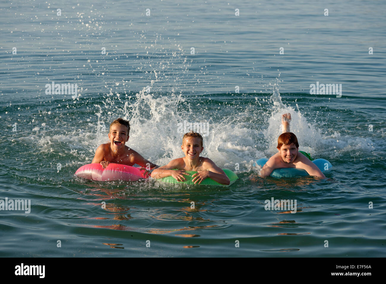 Kinder auf schwimmenden Reifen in das Meer, Mittelmeer in der Nähe von Fano, Marken, Adria, Italien Stockfoto