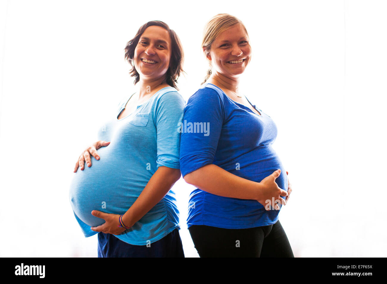 Schwangere Frauen, die ihre Bäuche halten Stockfoto