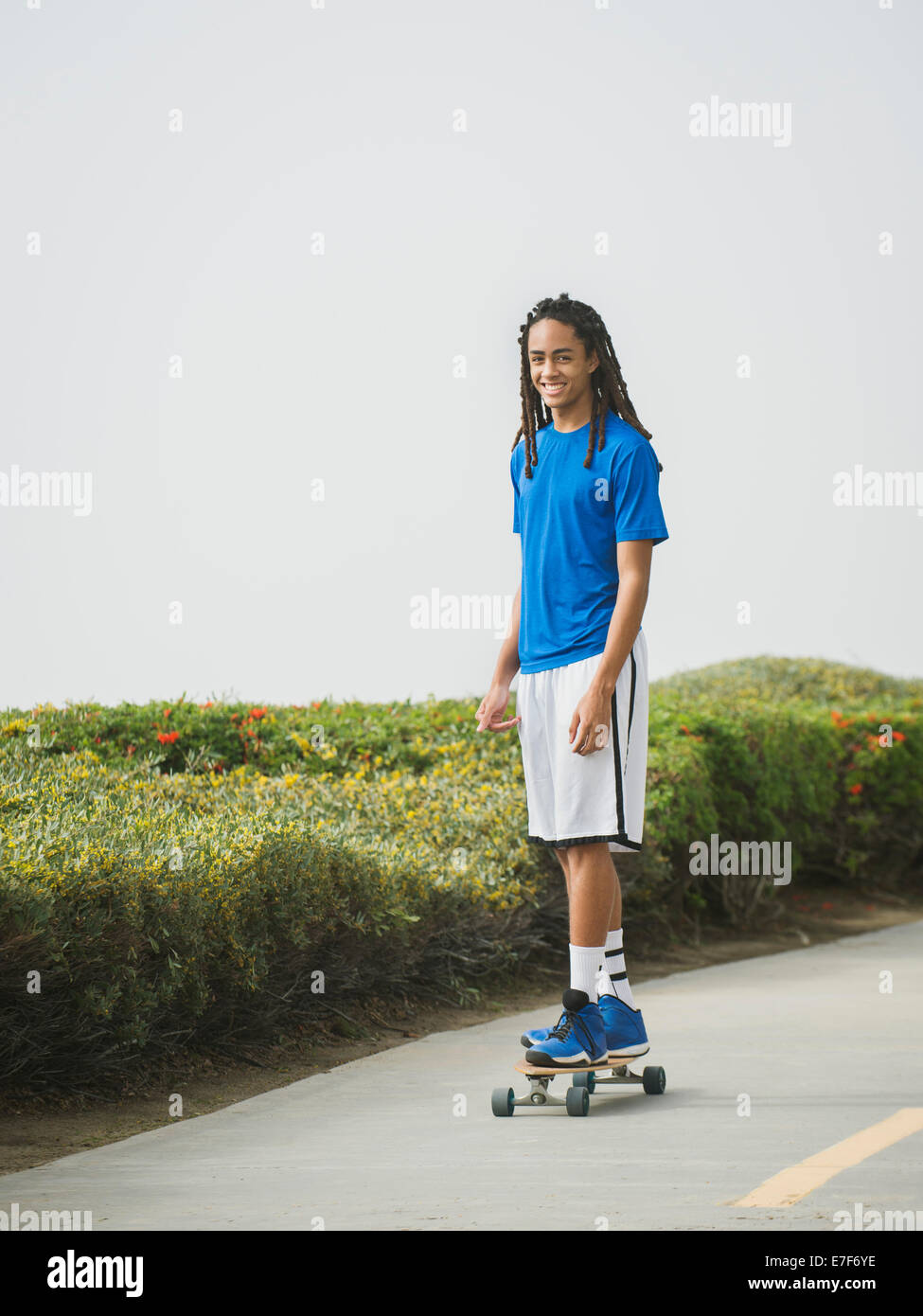 Schwarzer Teenager fahren Skateboard auf Straße Stockfoto