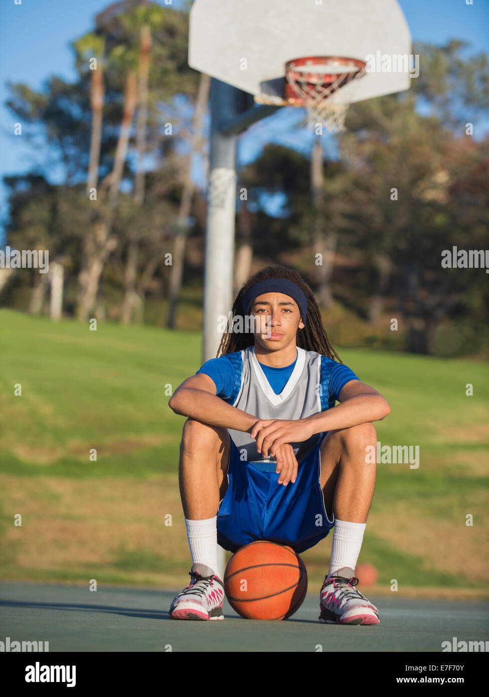 Schwarzer Teenager sitzen am Basketballplatz Stockfoto