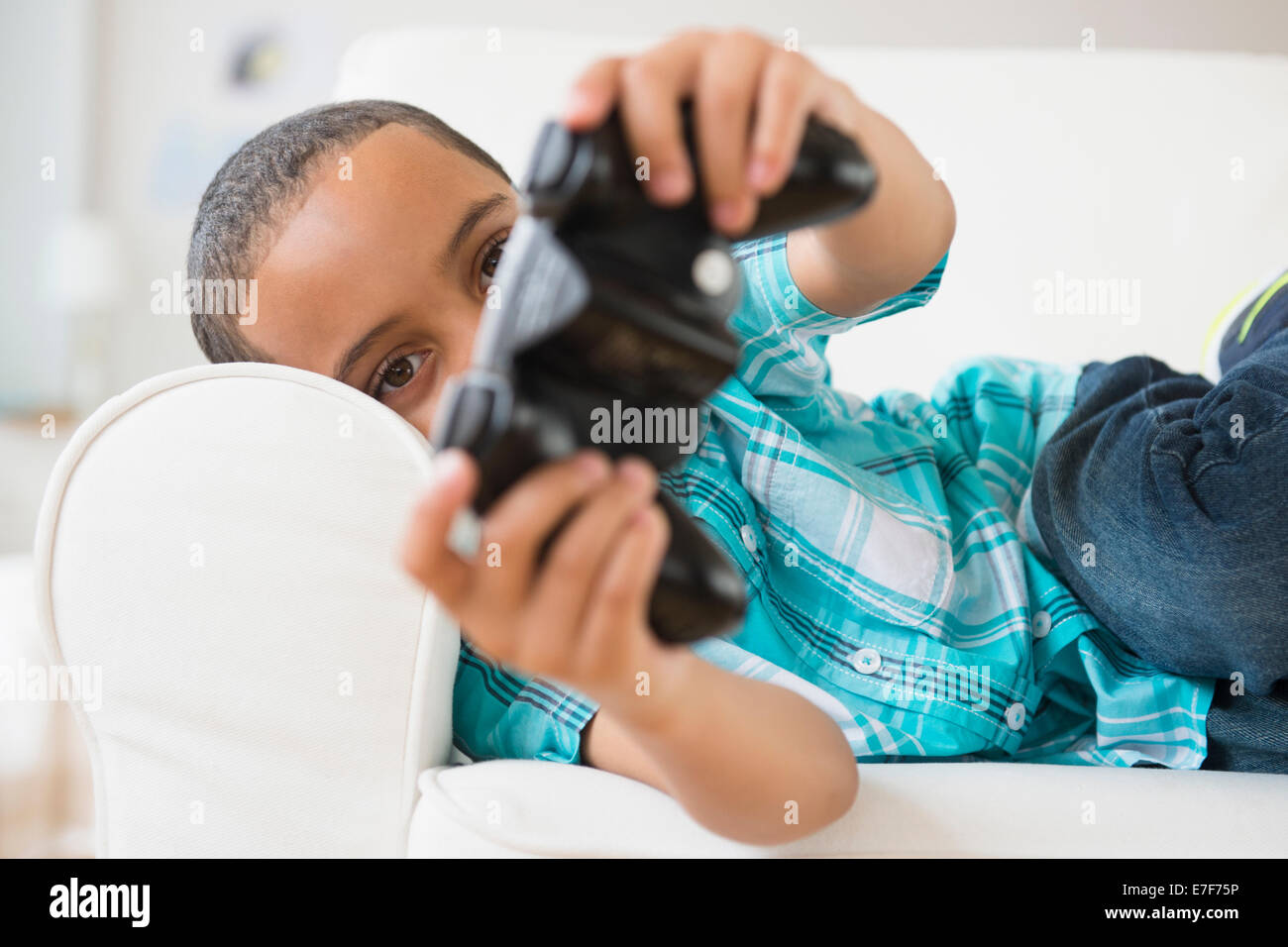Gemischte Rassen junge spielen von Videospielen Stockfoto