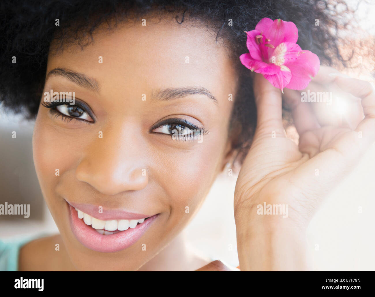 Afroamerikanische Frau Blume im Haar tragen Stockfoto