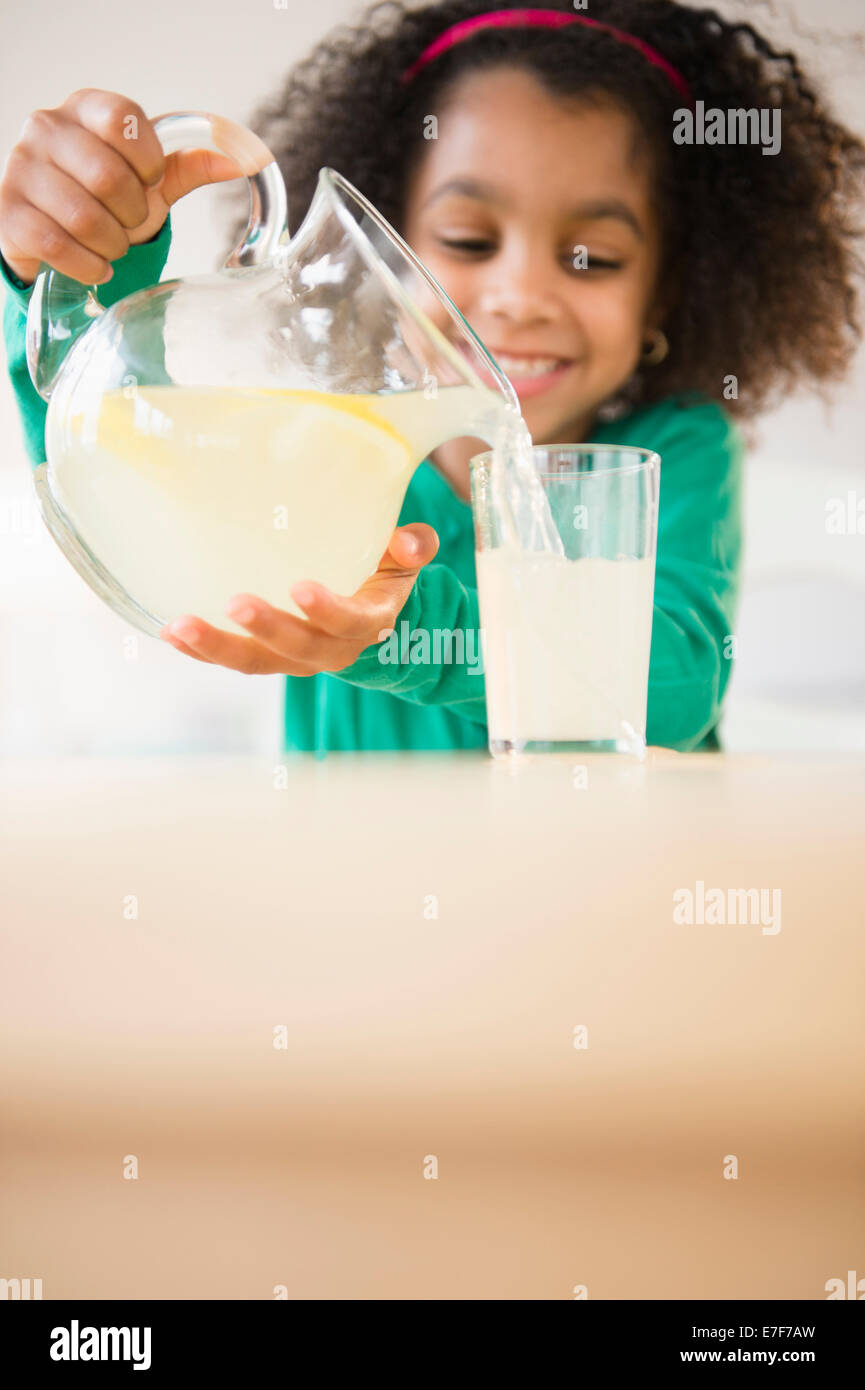 Afroamerikanische Mädchen Gießen Glas Limonade Stockfoto