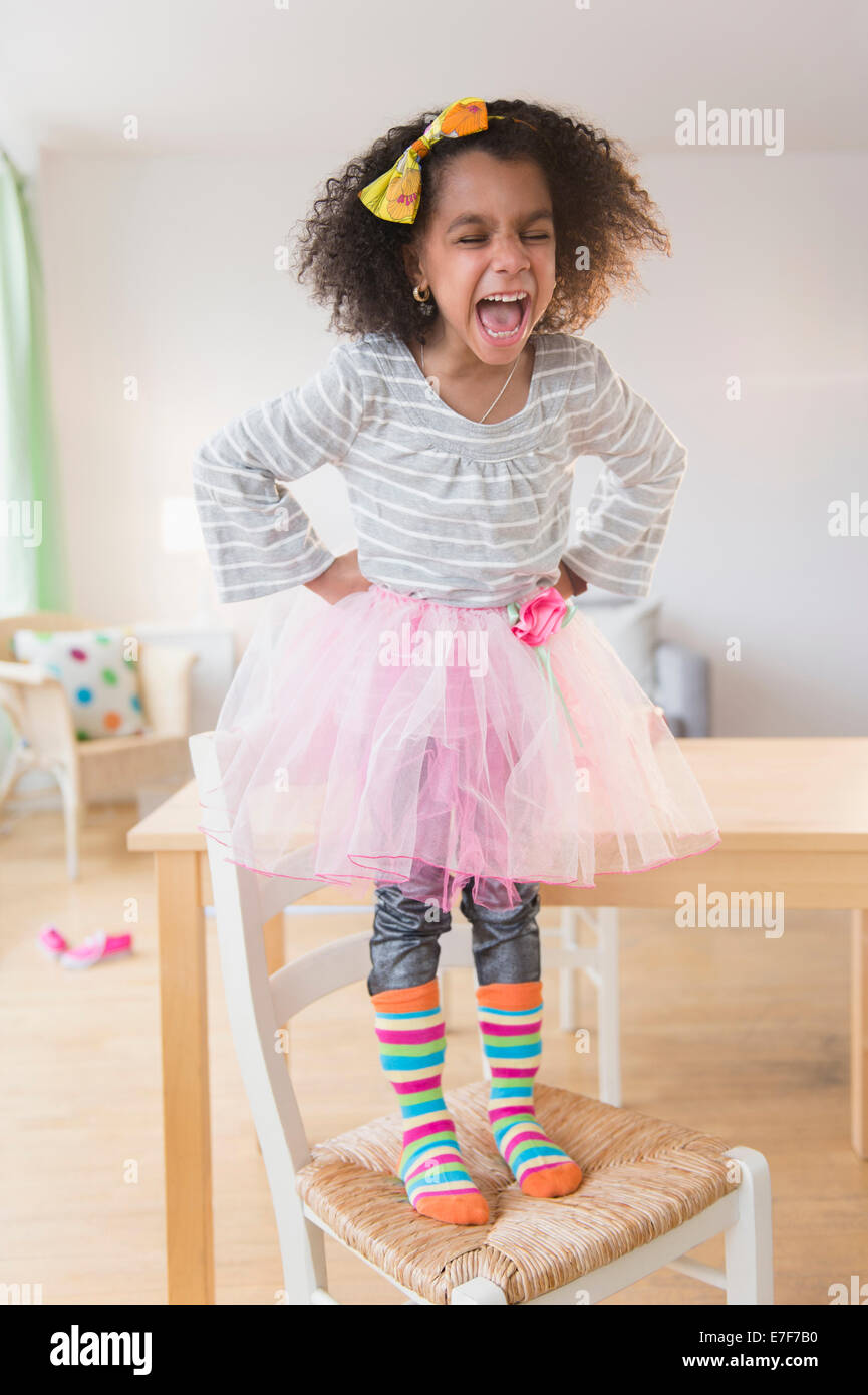 Afroamerikanische Mädchen schreien auf Stuhl Stockfoto