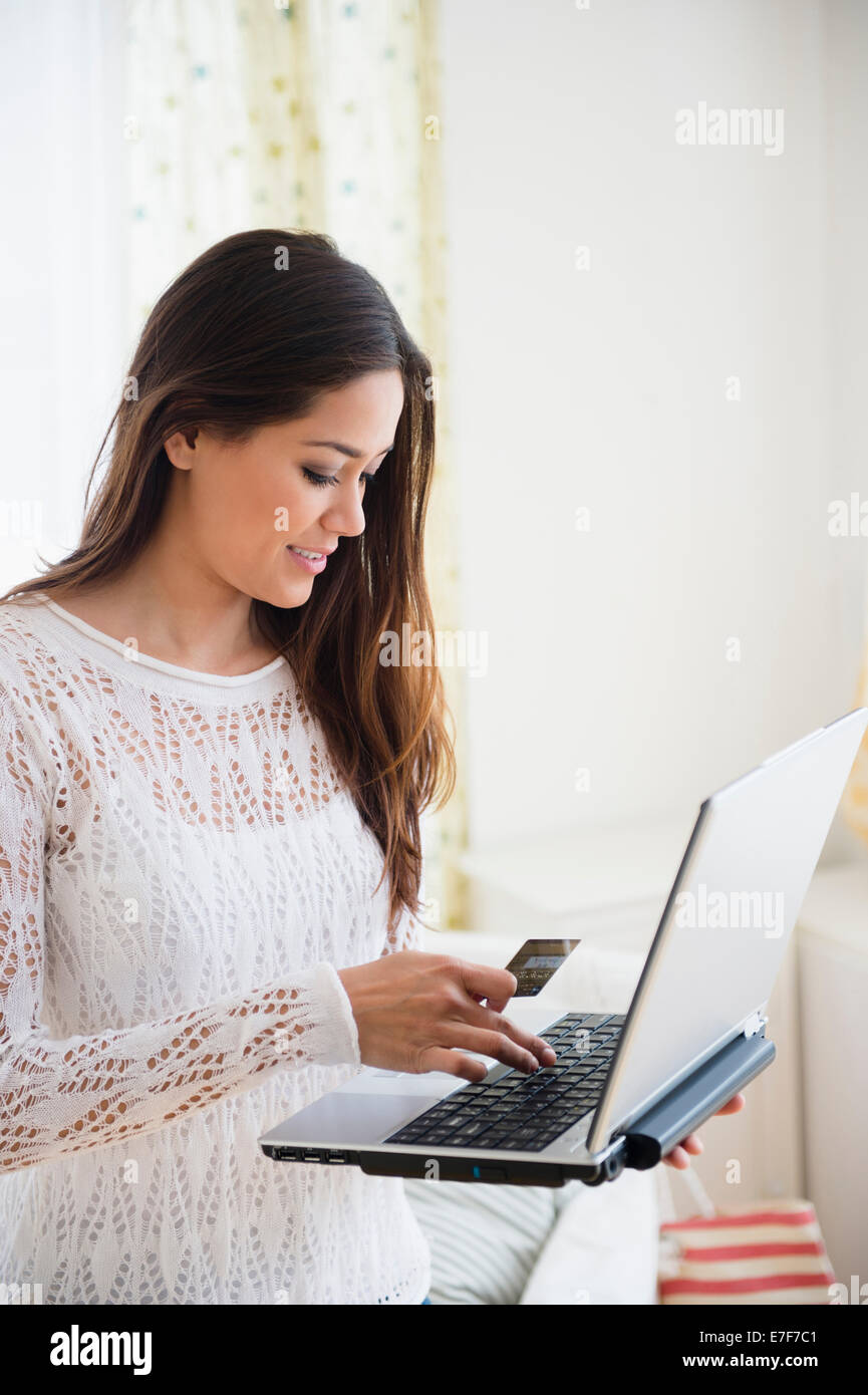 Frau mit Laptop im Schlafzimmer Stockfoto