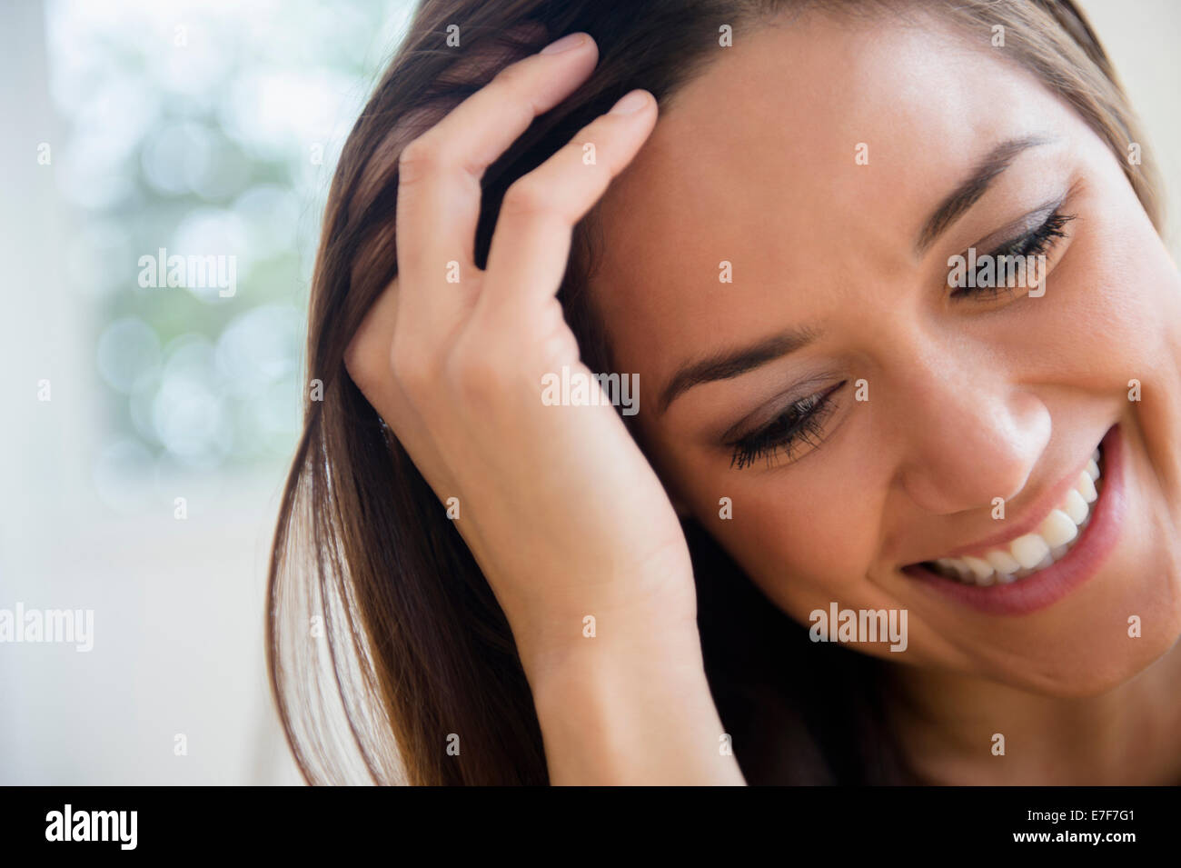 Frau mit Fingern durch ihr Haar Stockfoto