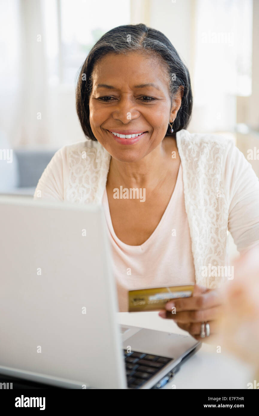Gemischte Rassen Frau einkaufen auf laptop Stockfoto