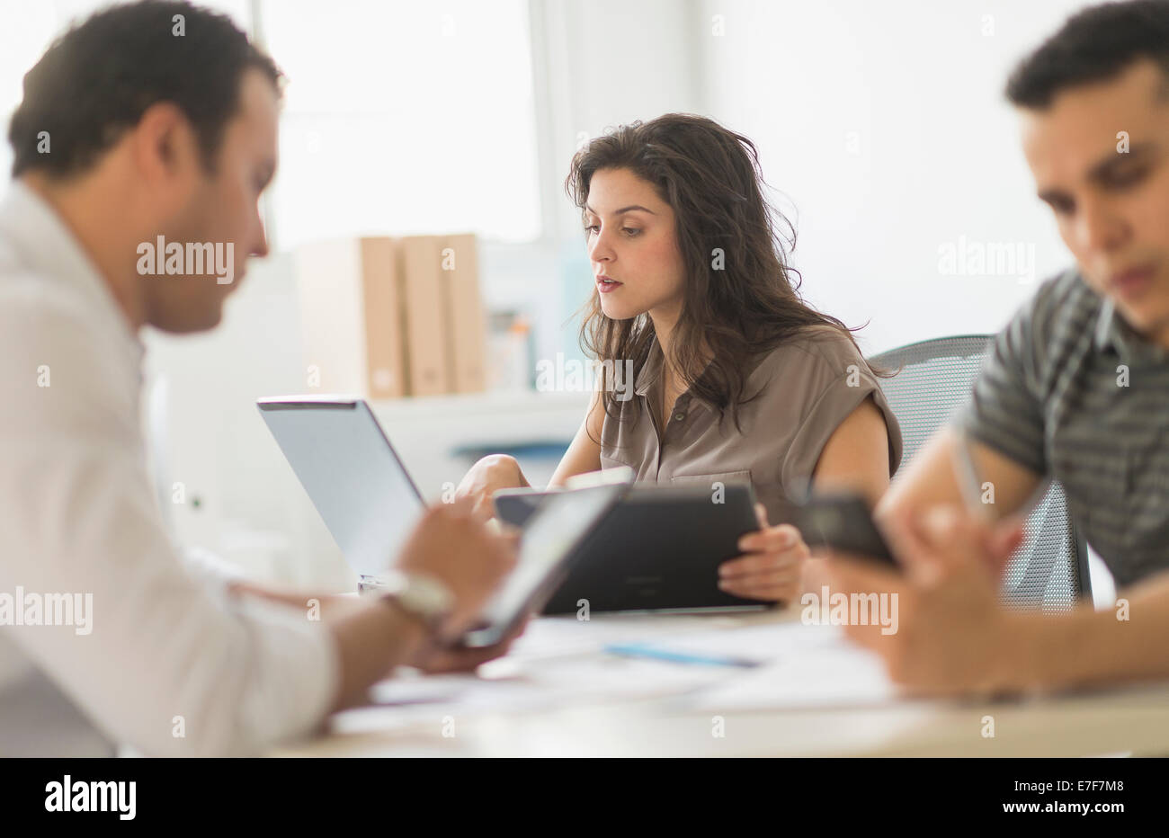 Hispanische Geschäftsleute mit Technik im Büro Stockfoto