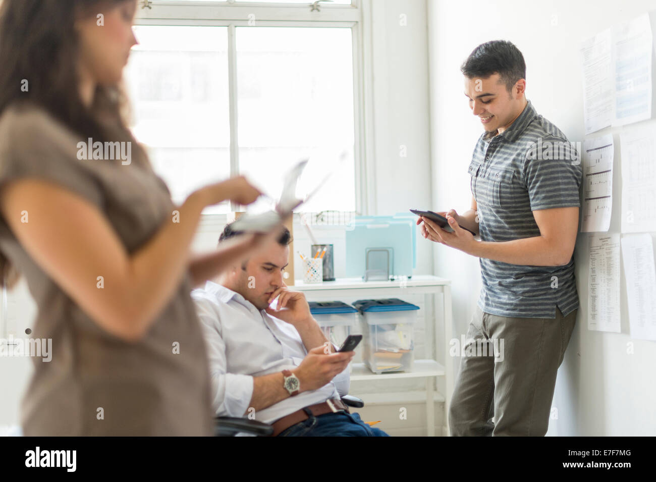 Hispanische Geschäftsleute mit Technik im Büro Stockfoto