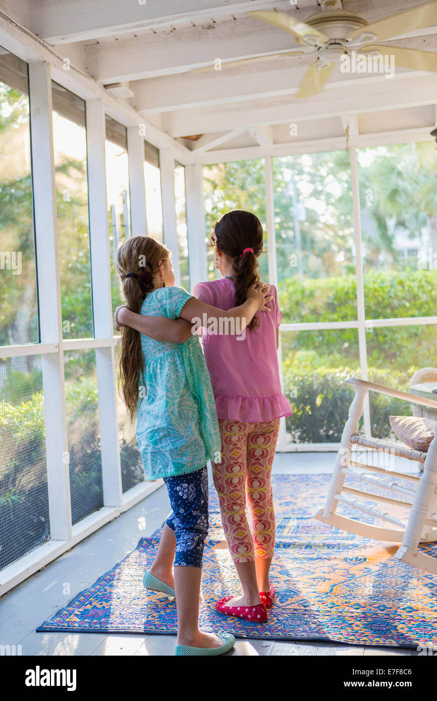 Mädchen umarmt auf Veranda Stockfoto