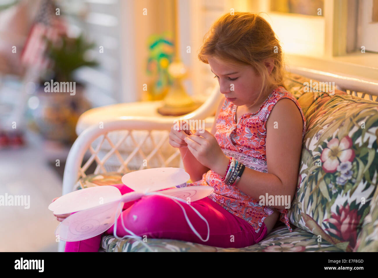 Kaukasische Mädchen Nähen Feenflügel auf sofa Stockfoto