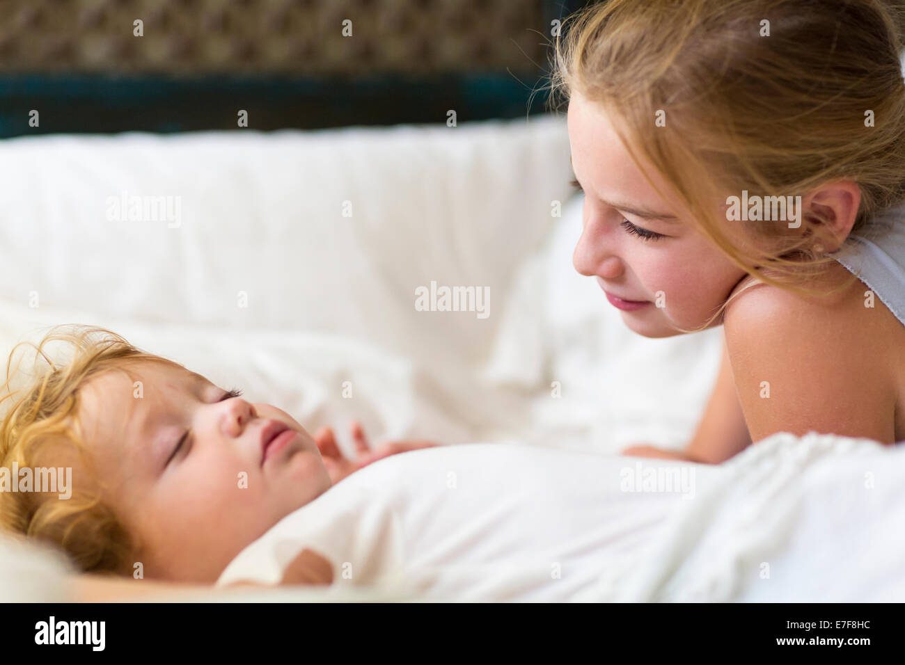 Kaukasische Mädchen und Kleinkind Bruder auf Bett Stockfoto