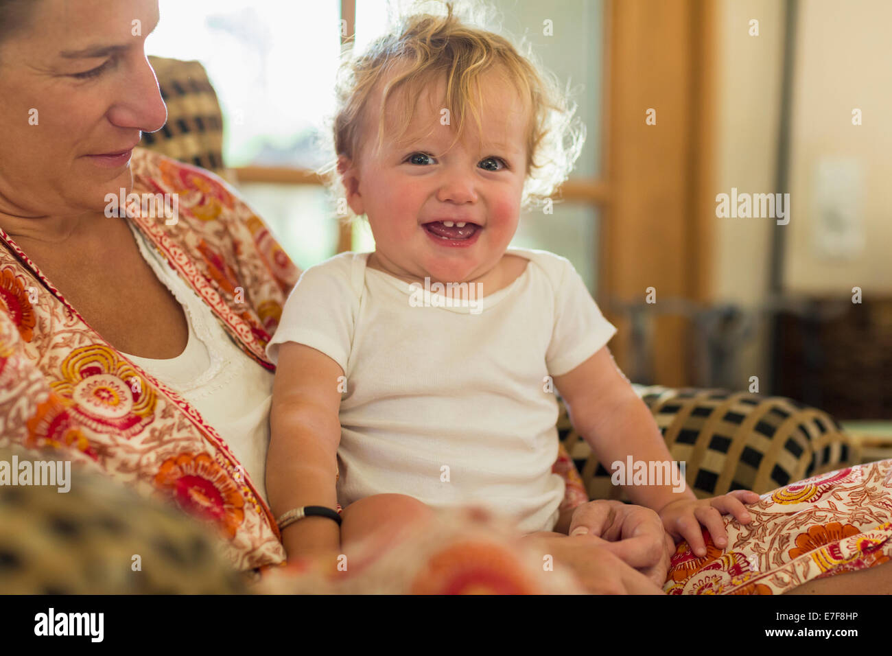 Kaukasische Mutter Holding Kleinkind im Wohnzimmer Stockfoto