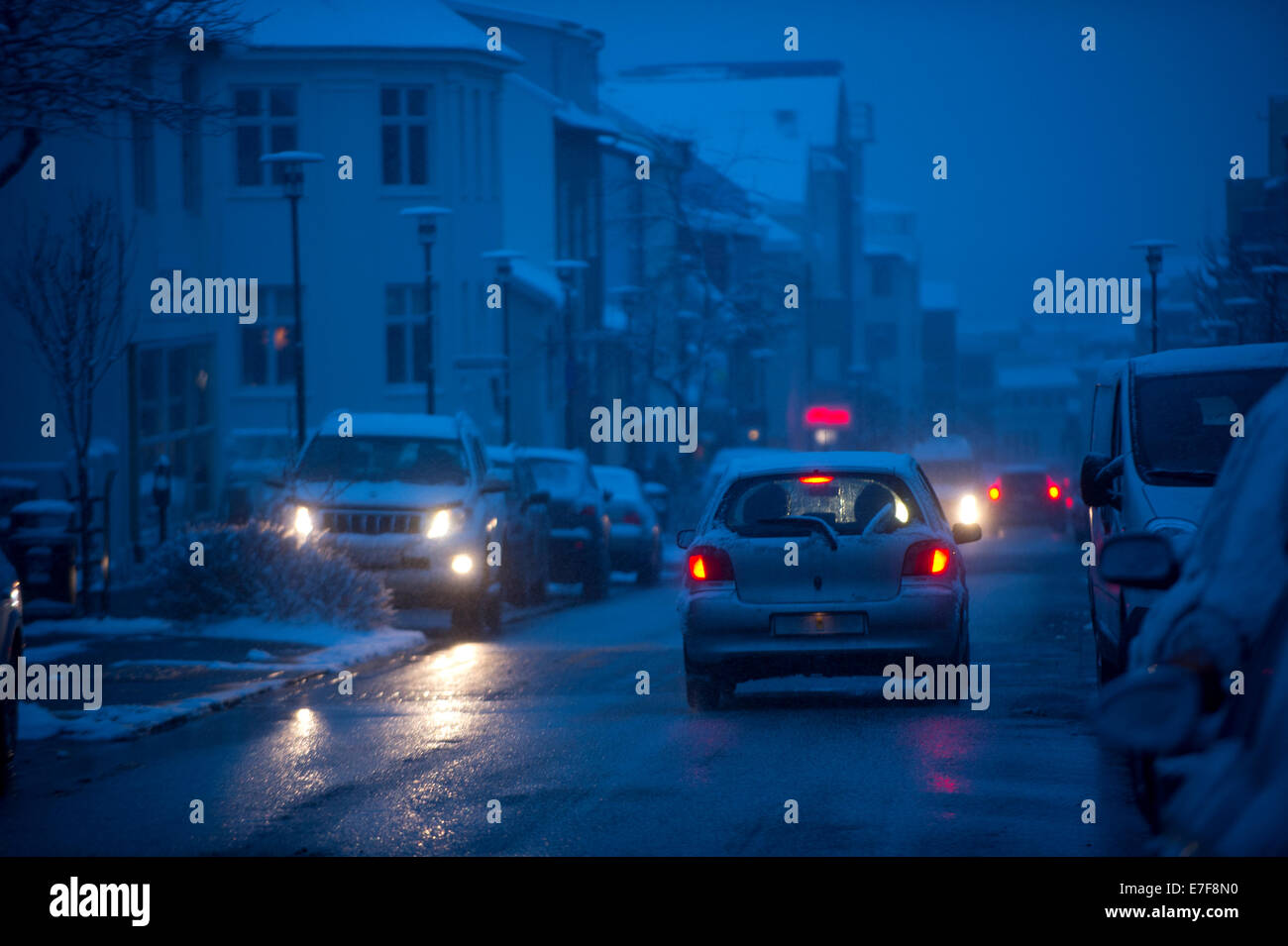 Autos fahren auf verschneiten Stadt Straße bei Nacht Stockfoto