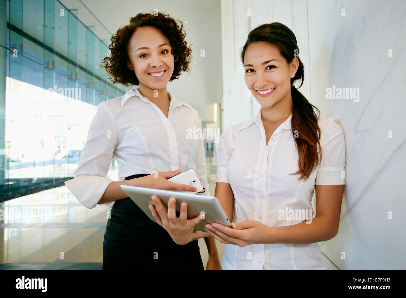 Unternehmerinnen mit Tablet-PC in der lobby Stockfoto