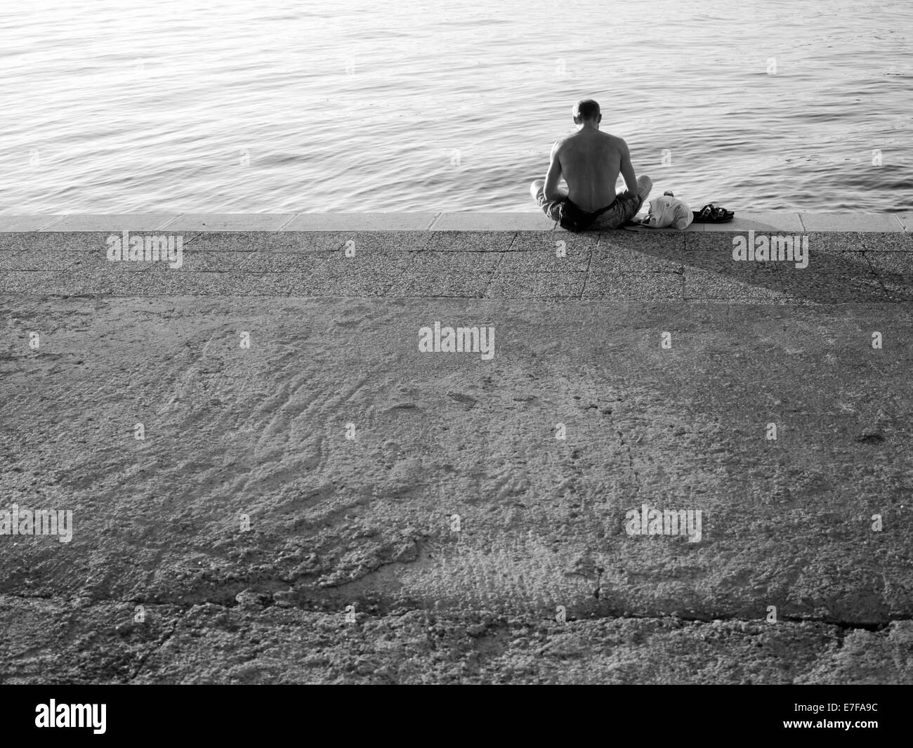 Muskulöser Mann auf der Anklagebank sitzen Meer zu beobachten. Fotografiert in Vrsar, Kroatien. Stockfoto