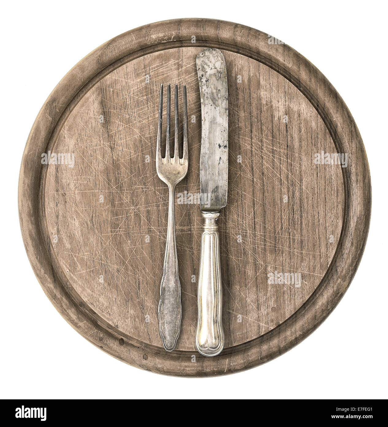 rustikales Holzbrett mit antiken Messer und Gabel isoliert auf weißem Hintergrund. Küchengeschirr und Vintage Silber Besteck Stockfoto