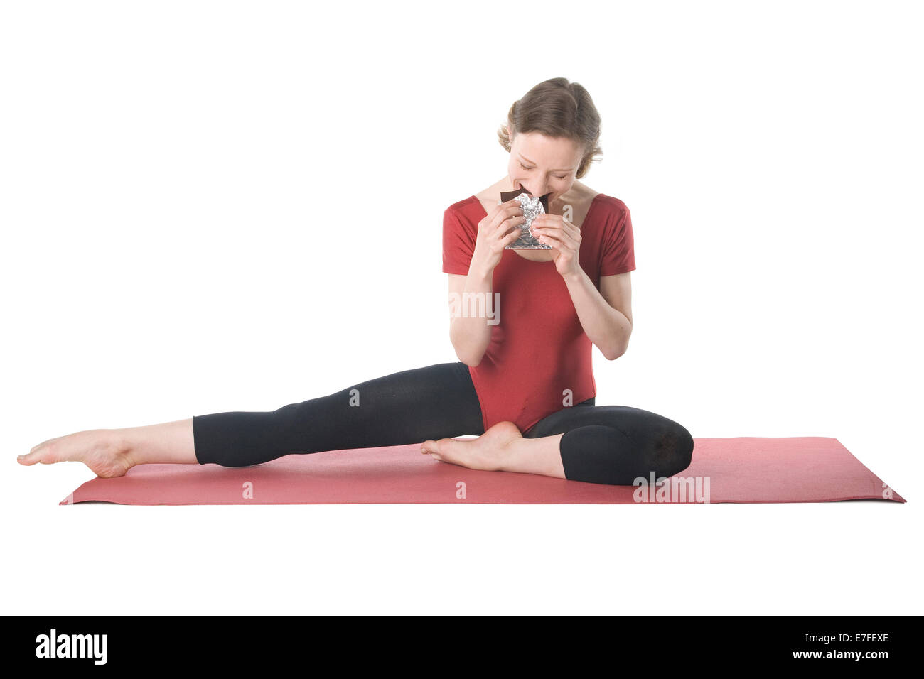 Junge Frau in Sportkleidung, Schokolade zu essen Stockfoto