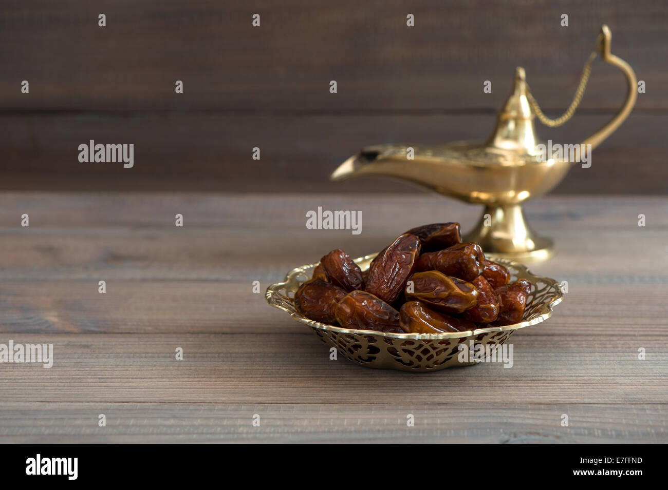 Termine in goldene Schale und Arabische Lampe auf hölzernen Hintergrund Stockfoto