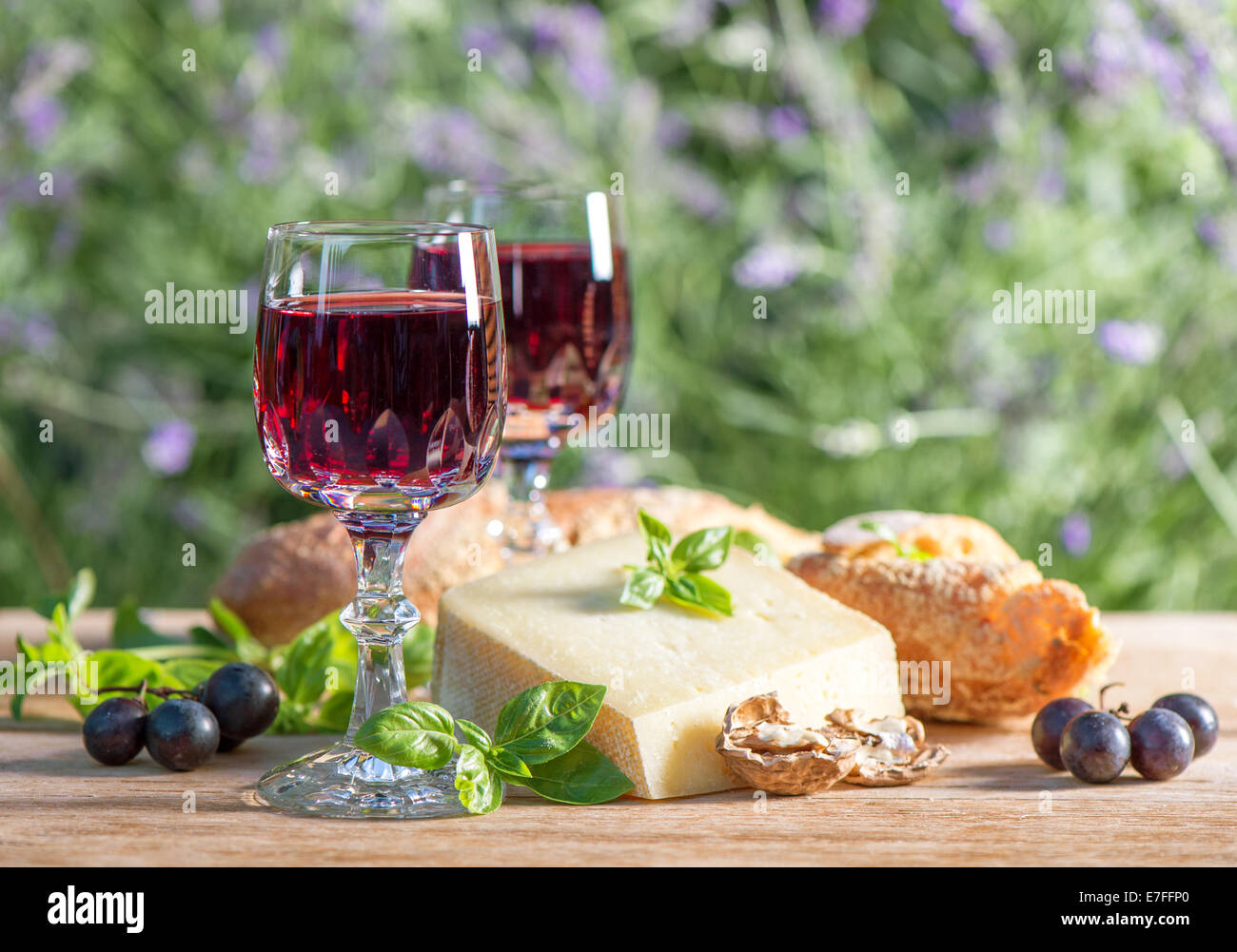 Käse mit Rotwein auf Holztisch im Freien. sonnigen Tag Stockfoto