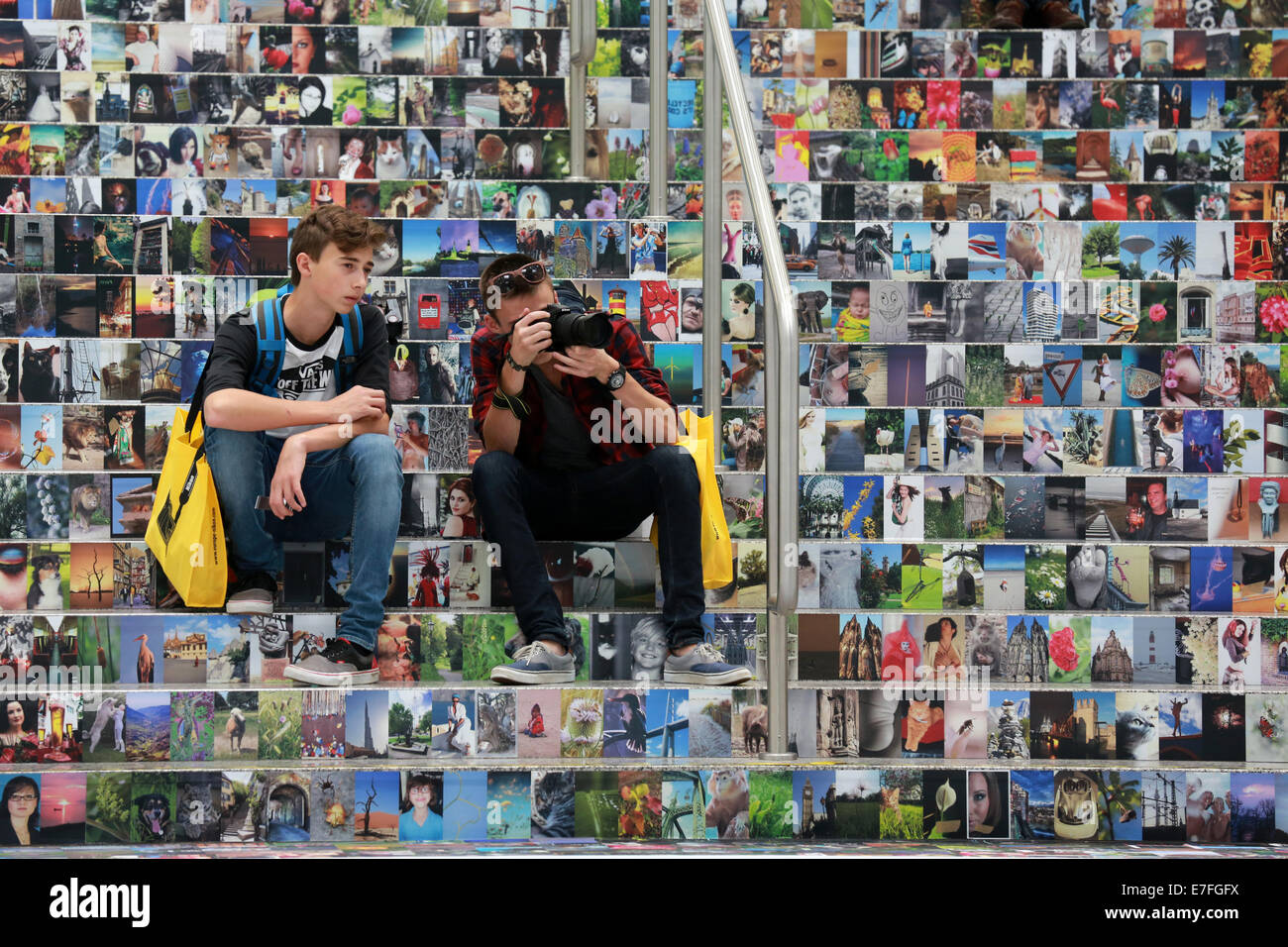 Besucher sitzen auf einer Treppe bedeckt mit Tausenden von Fotos, Photokina 2014, Köln, Deutschland Stockfoto