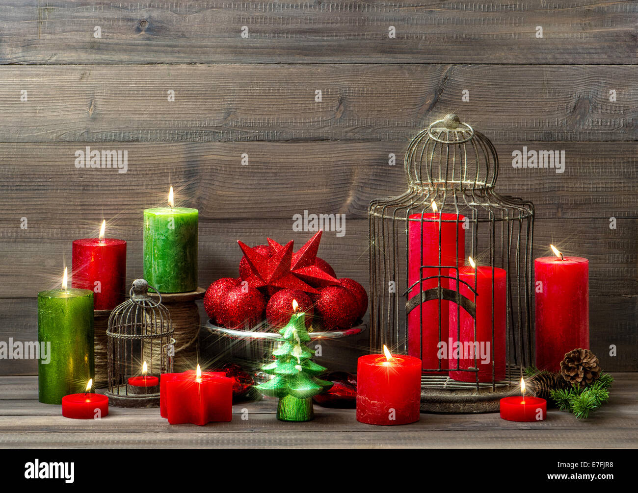 Weihnachts-Dekoration mit brennenden Kerzen, Christbaumkugeln, Vogelkäfig. nostalgische Wohngebäude mit magischen Lichtern Stockfoto