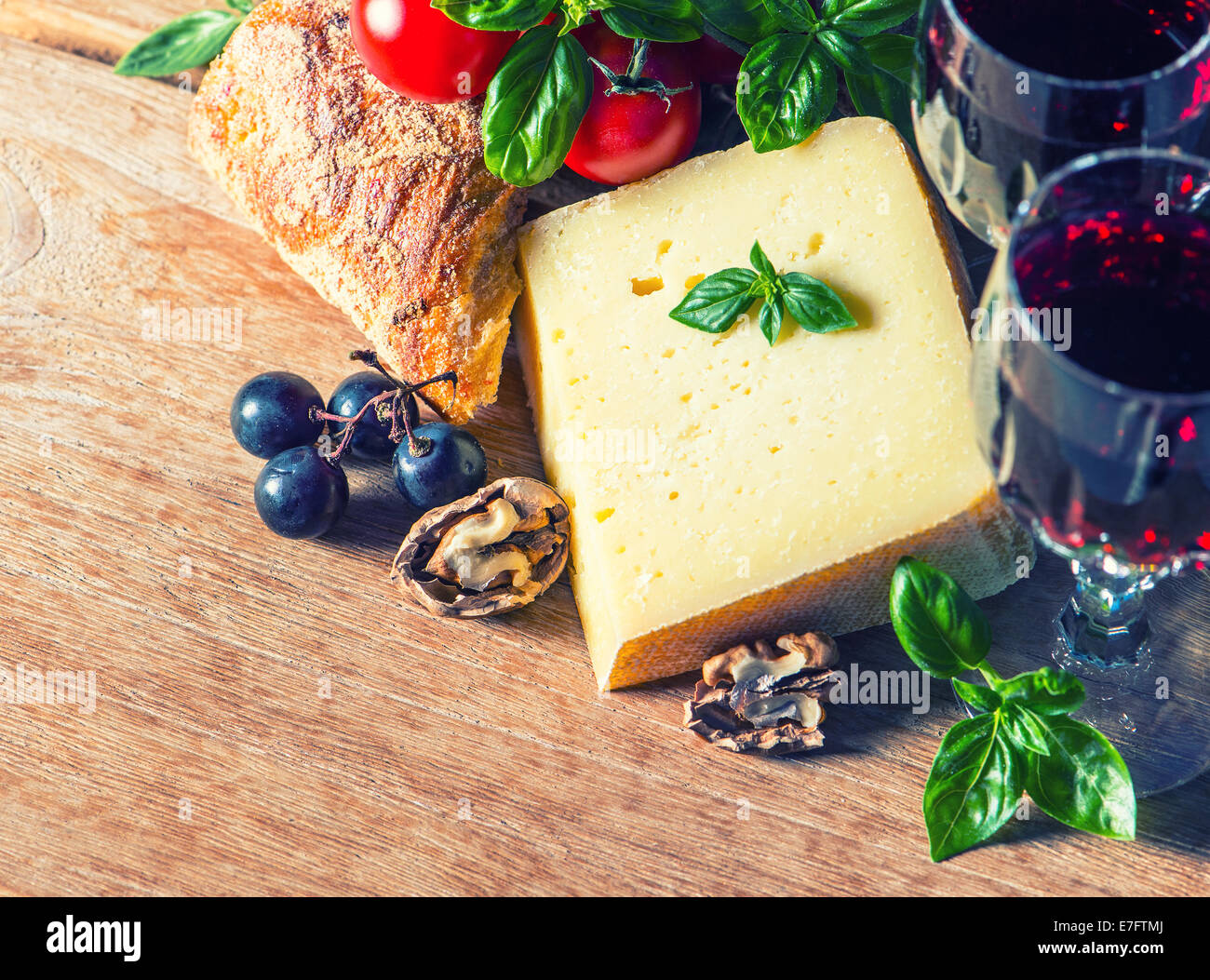 Käse mit Rotwein und Walnüsse. Essen und trinken. Retro-Stil getönten Bild Stockfoto