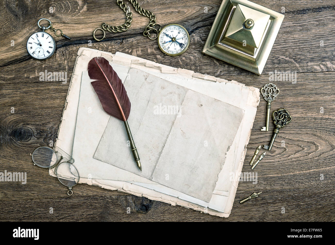 Retro-Office-Tools und schreiben Zubehör auf hölzernen Hintergrund. Antike Schlüssel, Taschenuhr, Feder Feder, Kompass. Vintage-Stil Stockfoto