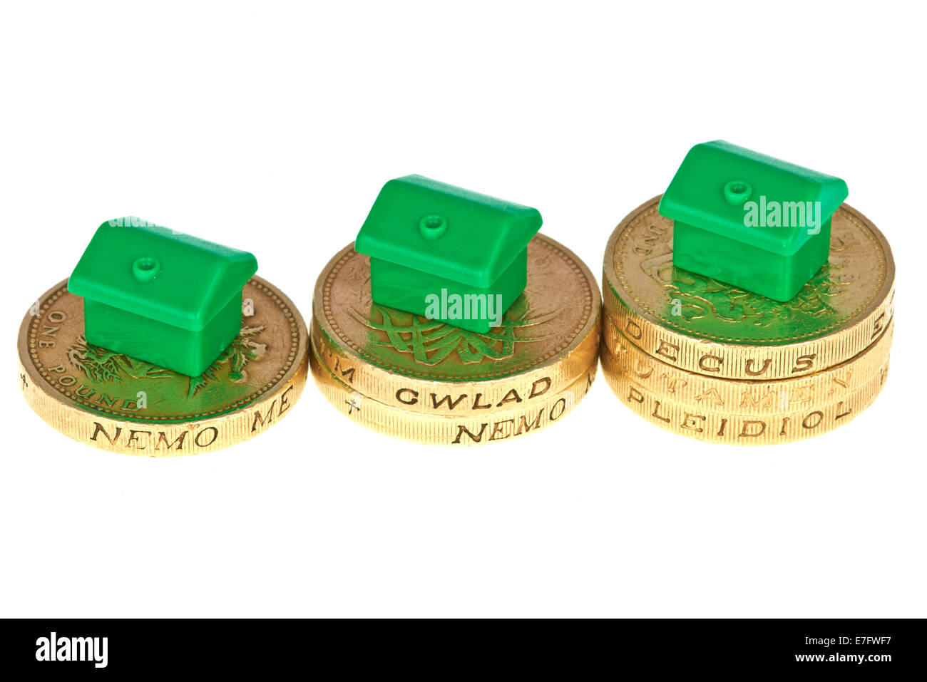 Monopol Häuser auf Rising Haufen Pfund-Münzen Stockfoto
