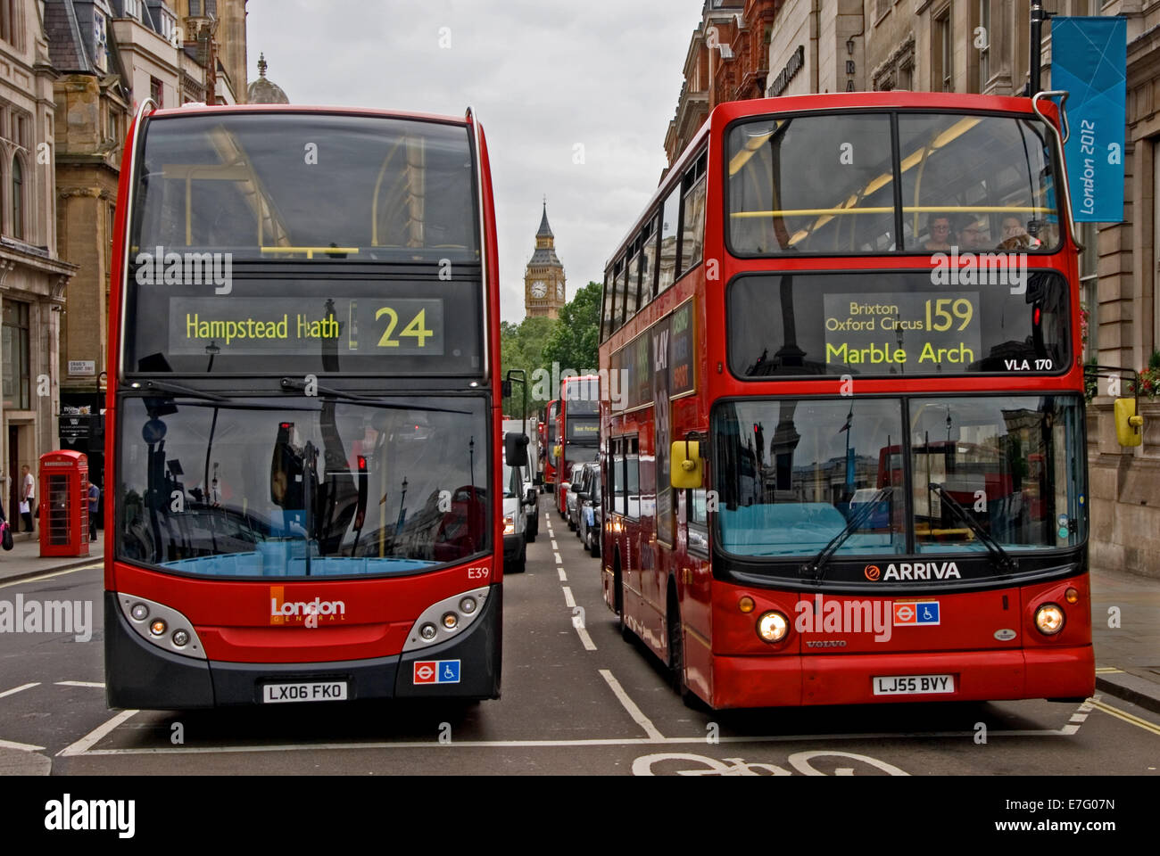 Zwei roten Londoner Busse warten an der Ampel, mit Big Ben am Horizont. Stockfoto