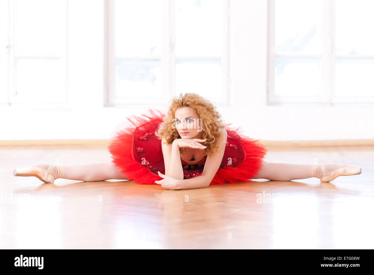 Schöne Ballerina in Split Lage, Blick in die Kamera mit einem Anspielungen Lächeln. Stockfoto