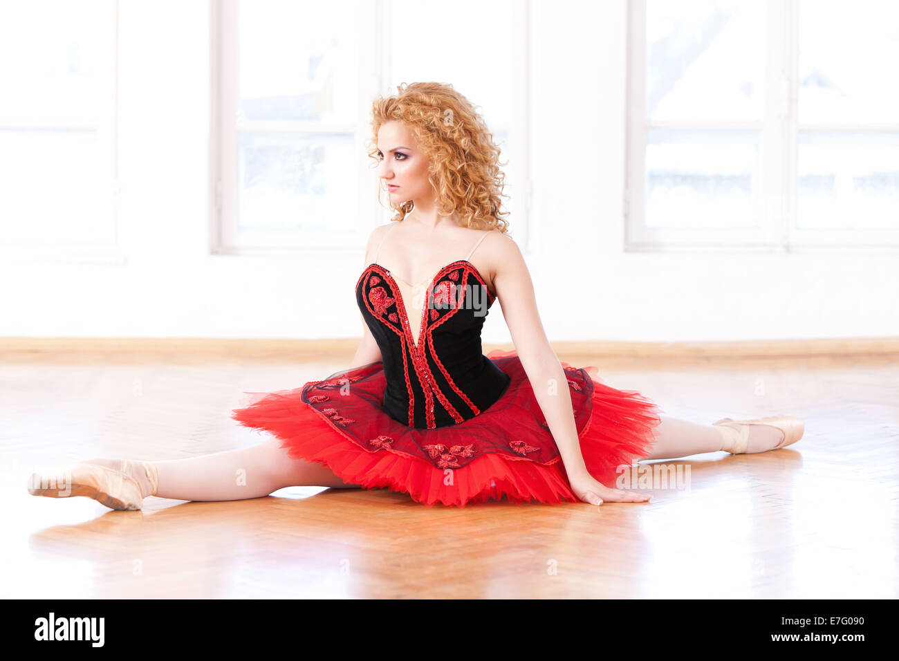 Sehr schöne Ballerina Profil in rot Tutu eine geteilte Position ausführen. Stockfoto