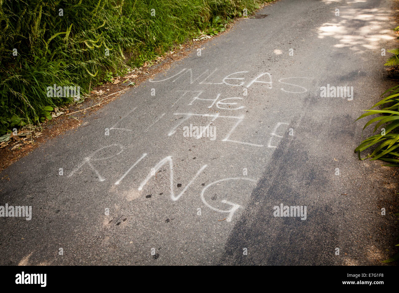 "Entfesseln den kleinen Ring" werden mit Kreide geschrieben, auf einem Radweg in Pembrokeshire, Wales Stockfoto