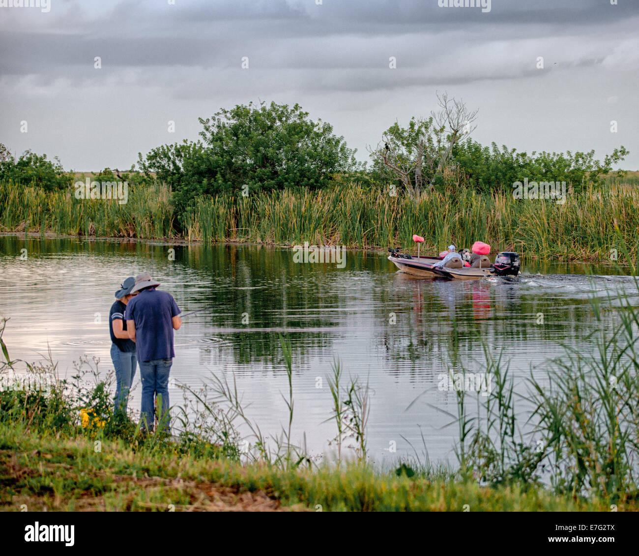 Florida, USA. 28. August 2014. Ein paar am Ufer überprüfen Sie ihre Angelrute, wie zwei Angler in einem Ranger 519VX Fischerboot mit einer 200 Evinrude e-Tec Außenbordmotor, in dem Arthur R. Marshall Loxahatchee National Wildlife Refuge, Palm Beach County, Florida, eine 147.392-Acre (596 qkm) passieren Wildlife Sanctuary und Teil des Everglades National Park. © Arnold Drapkin/ZUMA Draht/Alamy Live-Nachrichten Stockfoto